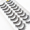 A display of dramatic mink false eyelashes arranged in a fan pattern on a white tray.