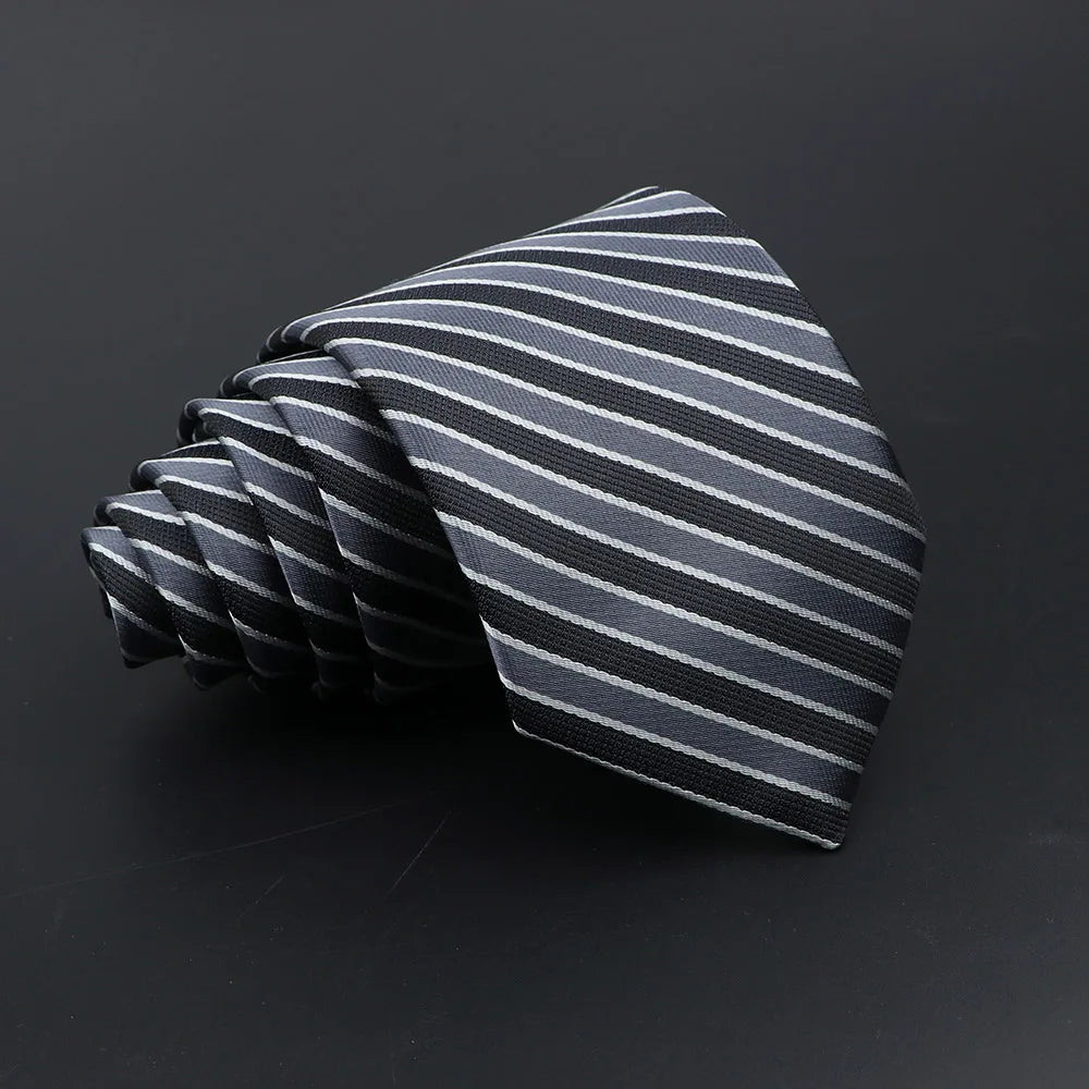 A folded gray and black striped men's tie displayed against a dark background.