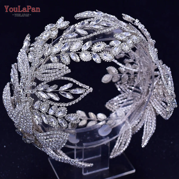 A sparkling rhinestone bridal tiara headpiece wreath displayed on a clear stand.