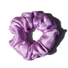 A purple silk hair scrunchie with gathered fabric, shown against a white background.