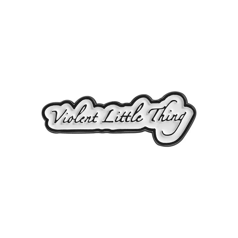 Black and white enamel lapel pin with the text Violent Little Thing