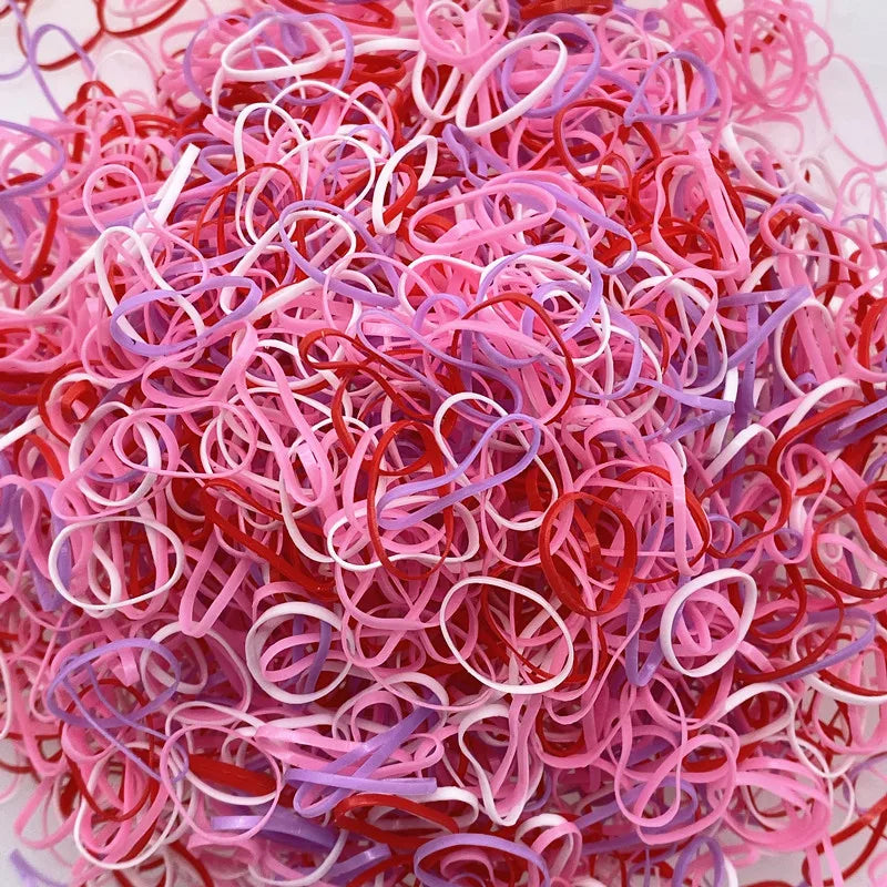 A pile of colorful disposable hair scrunchies in shades of pink, red, and purple.