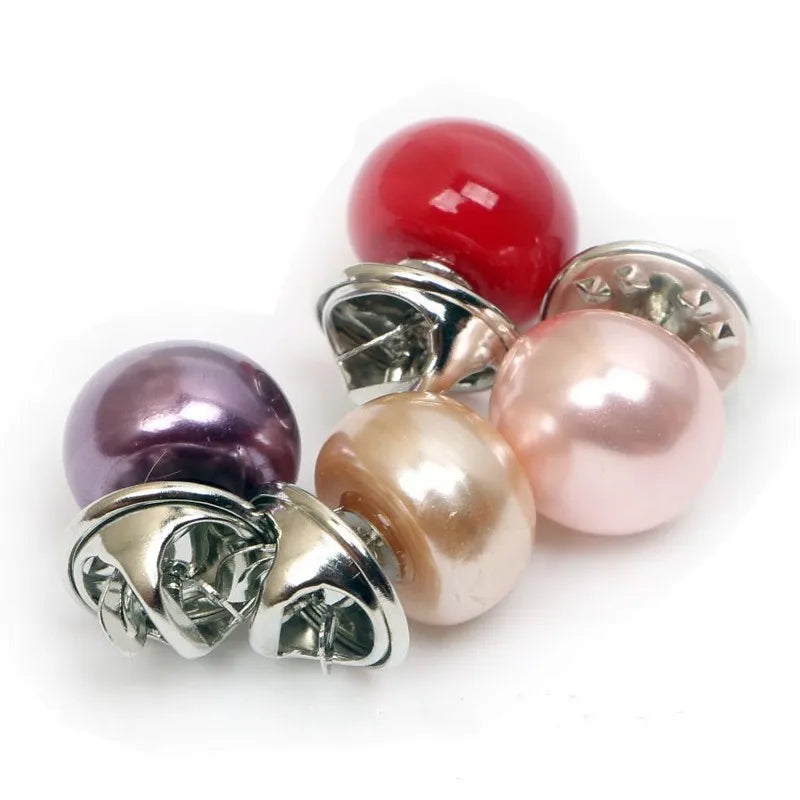 A set of five faux pearl buttons in shades of pink, red, and purple, displayed on a white background.