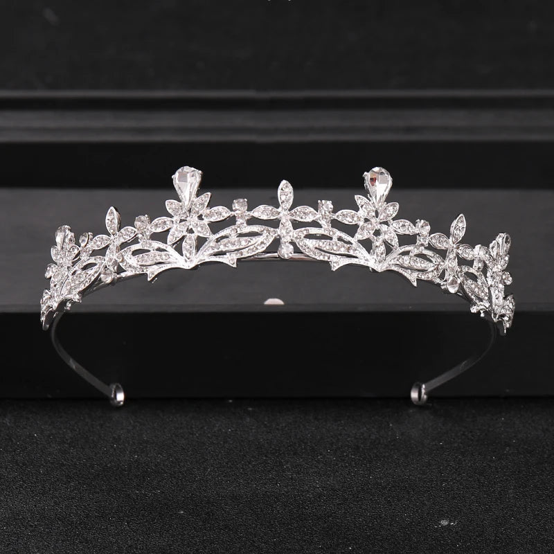 A sparkling crystal rhinestone bridal tiara headpiece displayed on a dark surface.