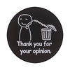 Insignia de esmalte negro con un dibujo lineal de una persona dando una opinión y el texto Gracias por tu opinión.