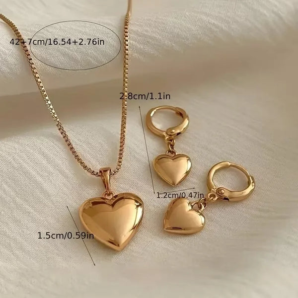 A delicate gold heart necklace and matching hoop earring set displayed on a white background.