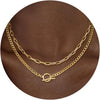 Gold layered Cuban link necklace displayed on a brown fabric background.