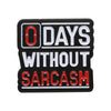 Insignia de esmalte negro con el texto DAYS WITHOUT SARCASM en letras blancas y rojas