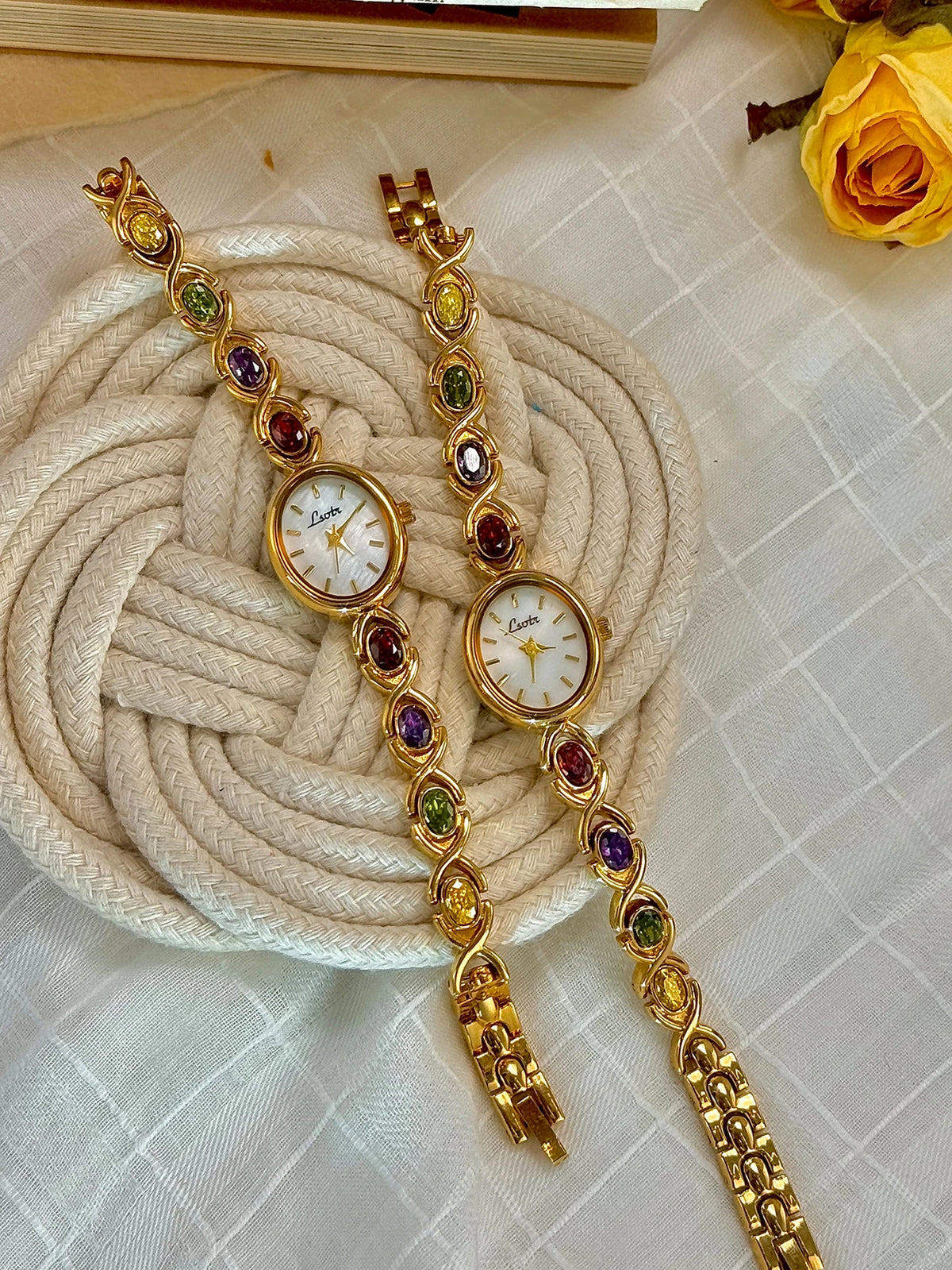 Goldfaruener Fashion-Armband mit zarter Kette und farbigen Edelsteinen auf der Zifferblatt.