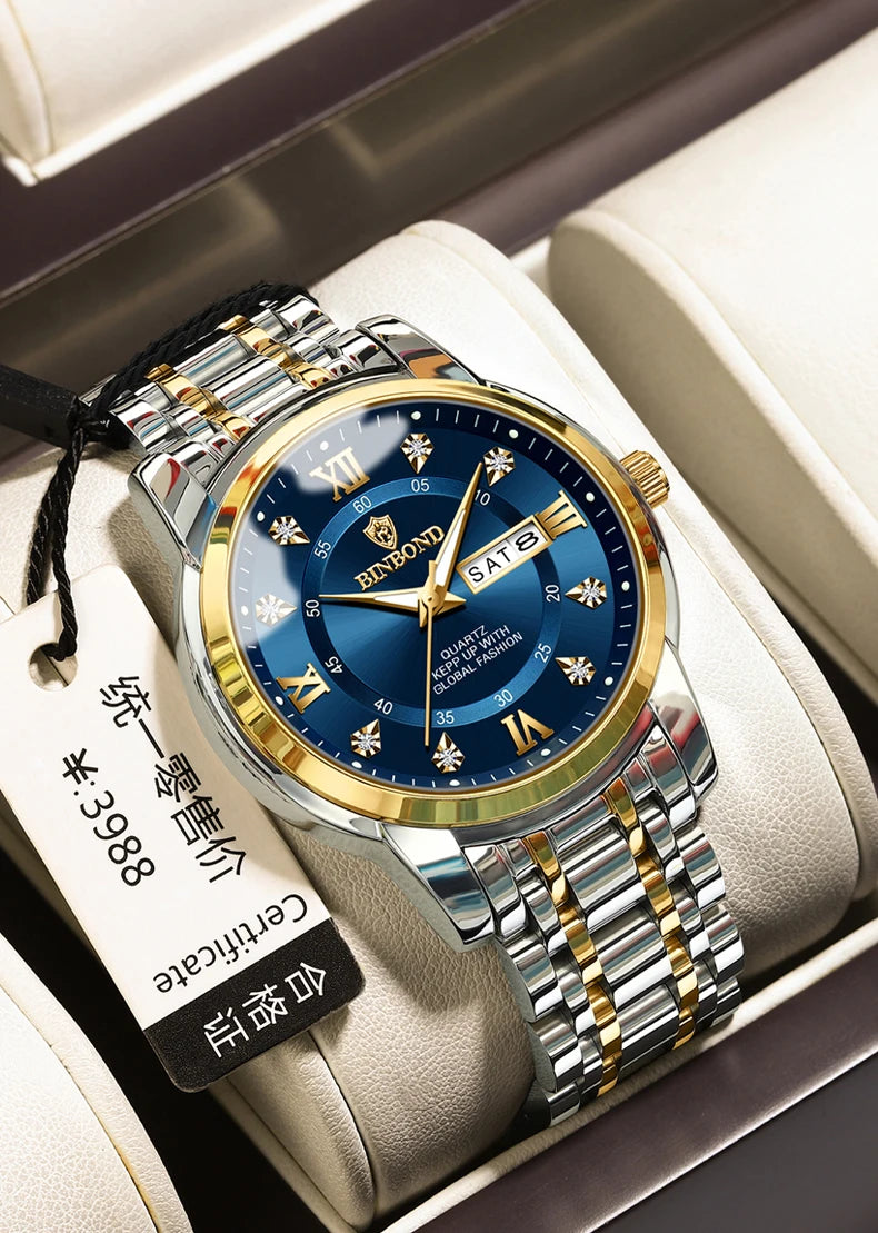 Reloj de pulsera de cuarzo para hombre plateado y dorado con esfera azul y correa negra, mostrado en una caja de color claro.