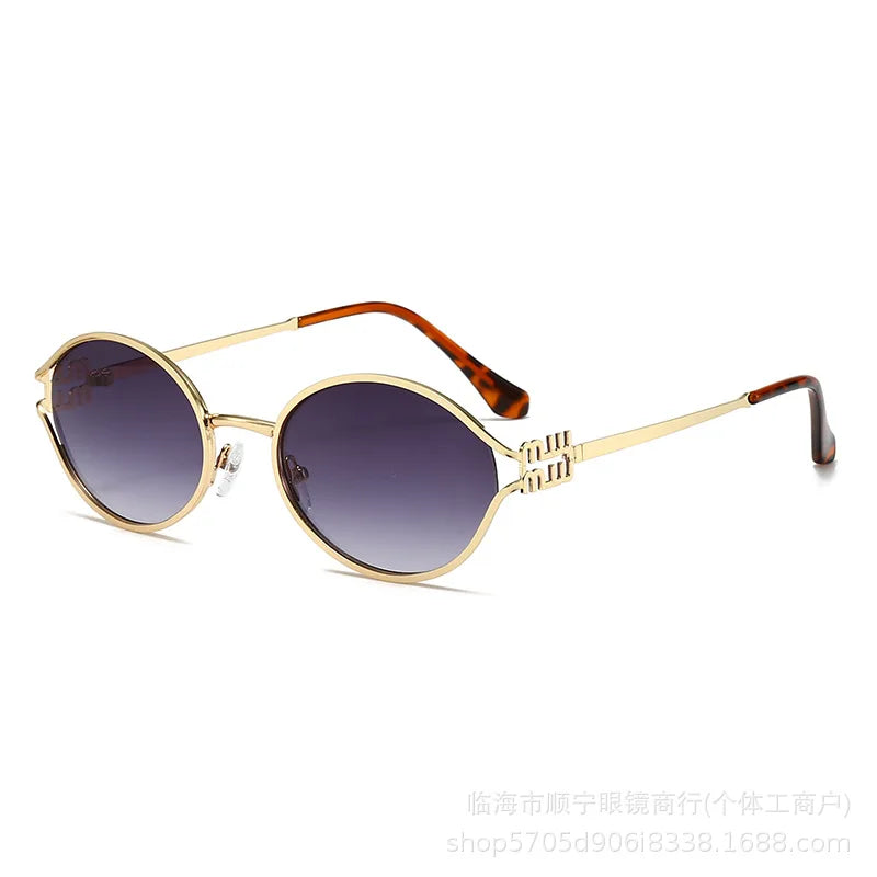 Goldgerahmte retro ovale Sonnenbrille mit dunklen Gläsern und Schildpattacc-Akzenten