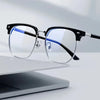 A pair of black and blue-rimmed retro half gold anti blue light eyeglasses resting on a white surface.