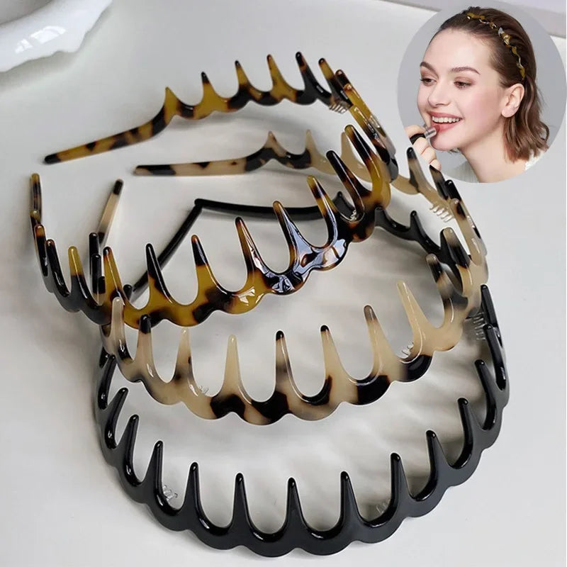 A set of black and amber fashion acetate toothed headbands displayed on a white background.
