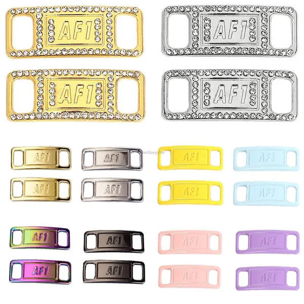 A collection of various colored metal shoe charms and laces in gold, silver, yellow, blue, pink, and purple finishes.