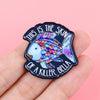 Broche émail sombre représentant un poisson stylisé à corps coloré et texturé avec le texte : This is the skin of a killer Be