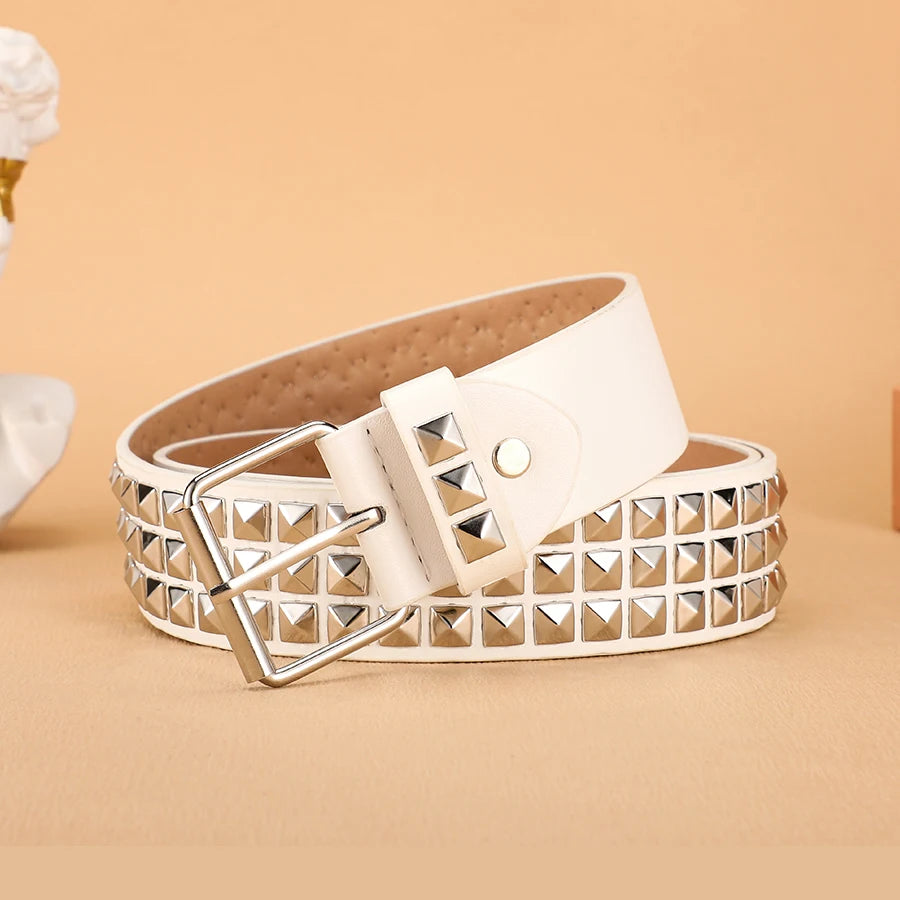 A beige leather belt featuring silver metal rivets and a white rectangular buckle.