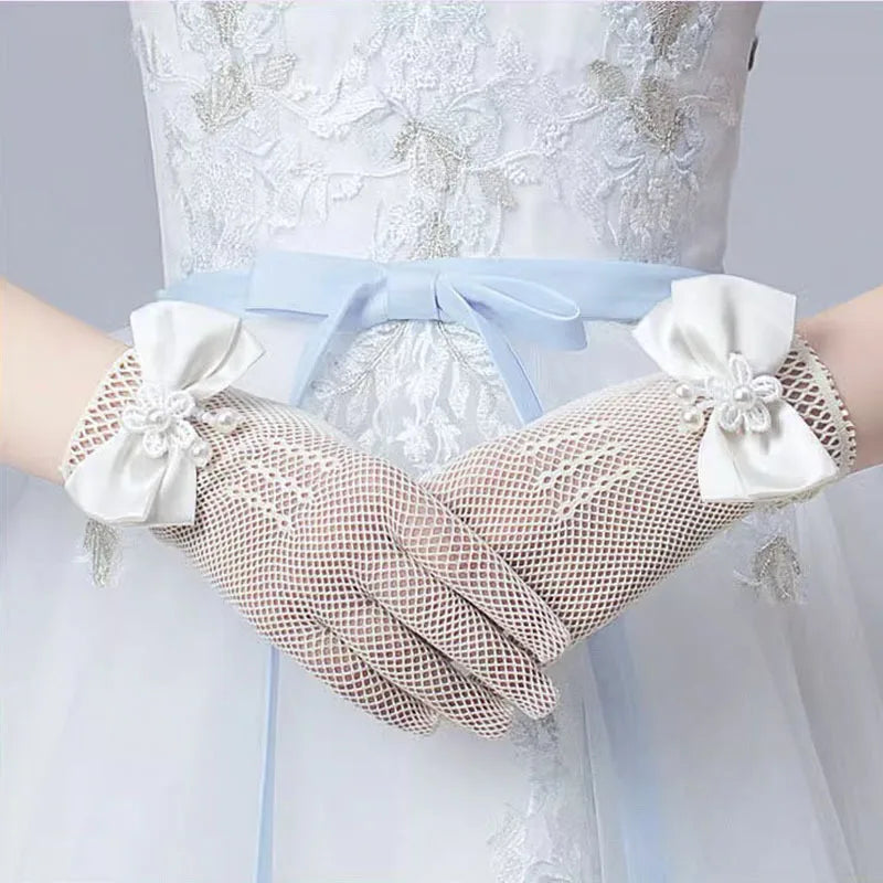 White lace bridal gloves with sheer mesh fabric and satin ribbon on a light blue dress