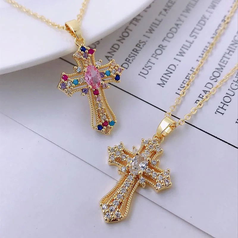 A gold dainty cross charm necklace with colorful gemstone accents displayed on a white background.