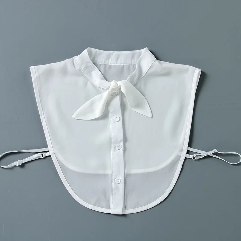 White sheer blouse with a false collar and detachable neckline, displayed flat.