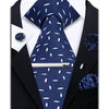 A dark blue patterned necktie and a dark blue floral lapel pin displayed against a black suit jacket.