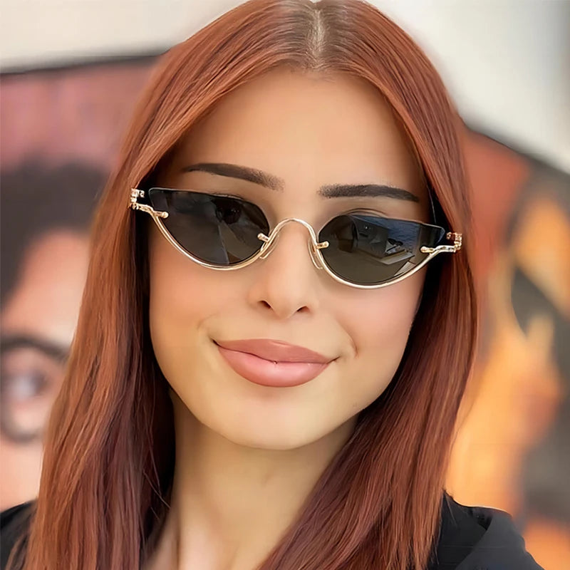 Una mujer modela gafas de gato retro con detalles dorados contra un fondo desenfocado.