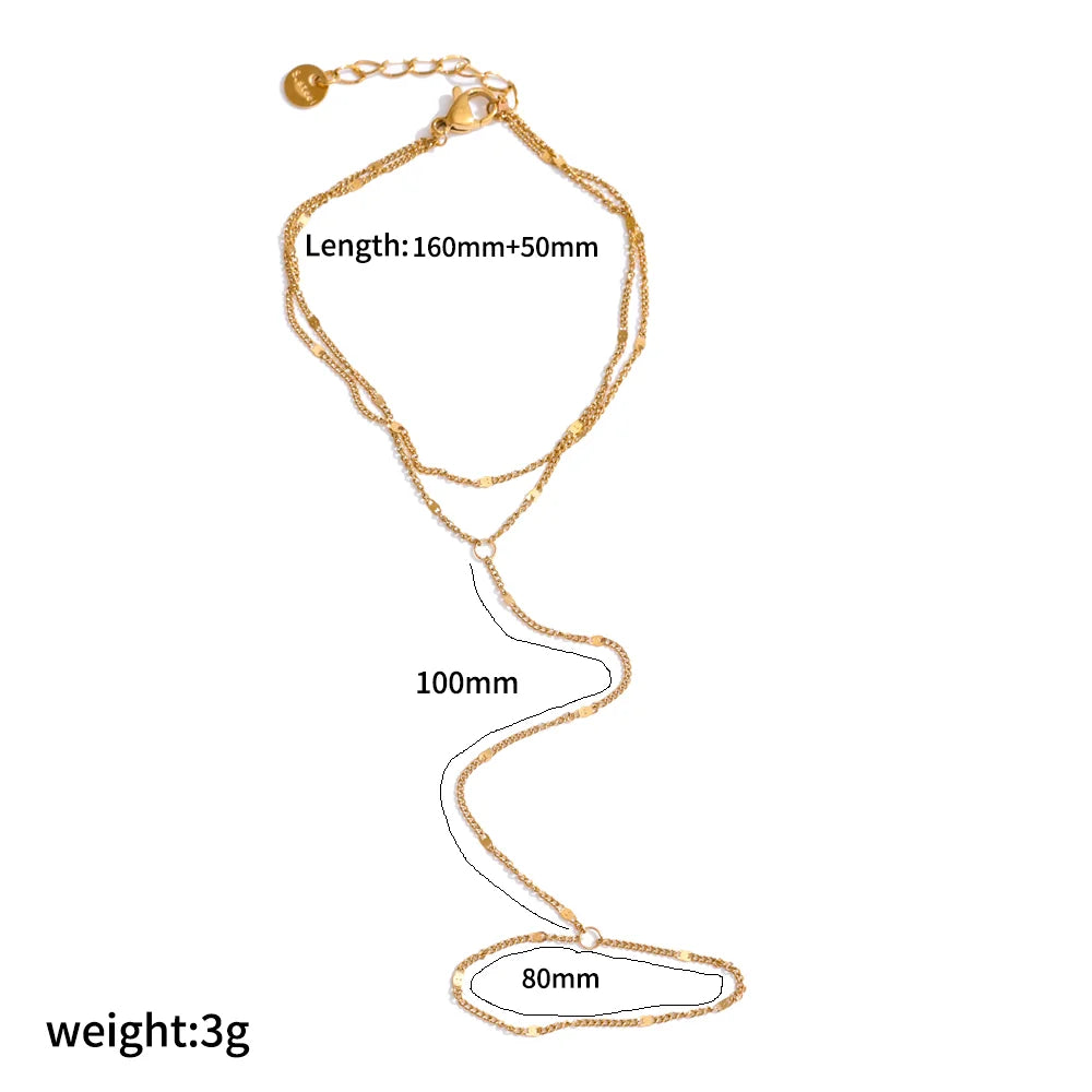 A delicate gold-plated stainless steel bracelet with a chain and a small charm.