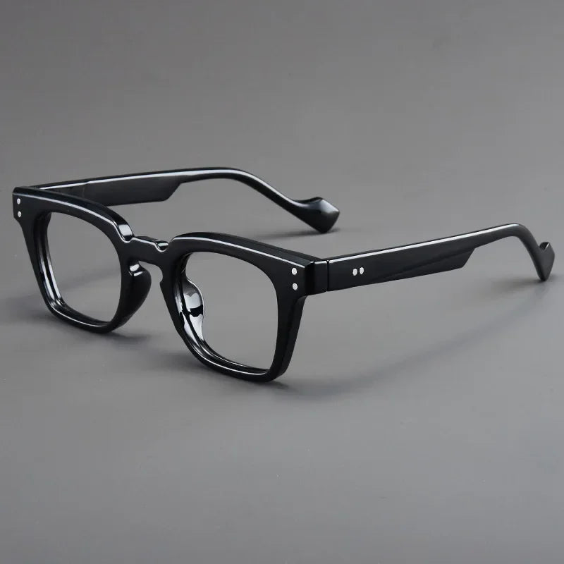 Lunettes de lecture noires anti-lumière bleue à monture unisexes légères, sur fond gris.