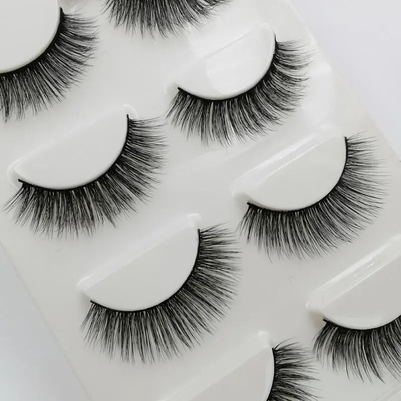 A set of handmade mink strip eyelashes displayed on a white tray.