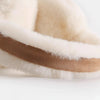 Close-up of classic winter ear muffs featuring light cream fur trim and a brown leather band.