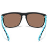 Une paire de lunettes noires avec des verres marron et des branches à motifs turquoise.