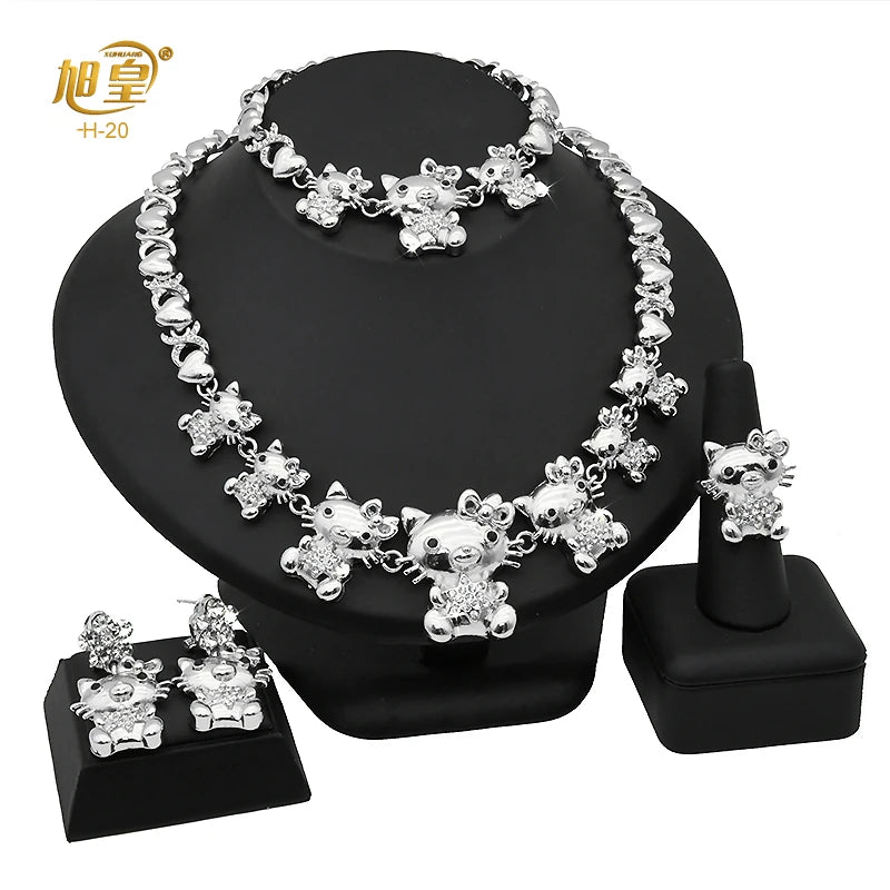 A necklace and matching earrings set featuring silver-toned heart crystal jewelry displayed on a black stand.