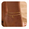 Primer plano de una pulsera y un arete de oro vintage puestos en la muñeca de una persona.
