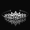 Tiara y corona de princesa de cristal brillante, accesorio para el cabello que refleja en una superficie oscura.