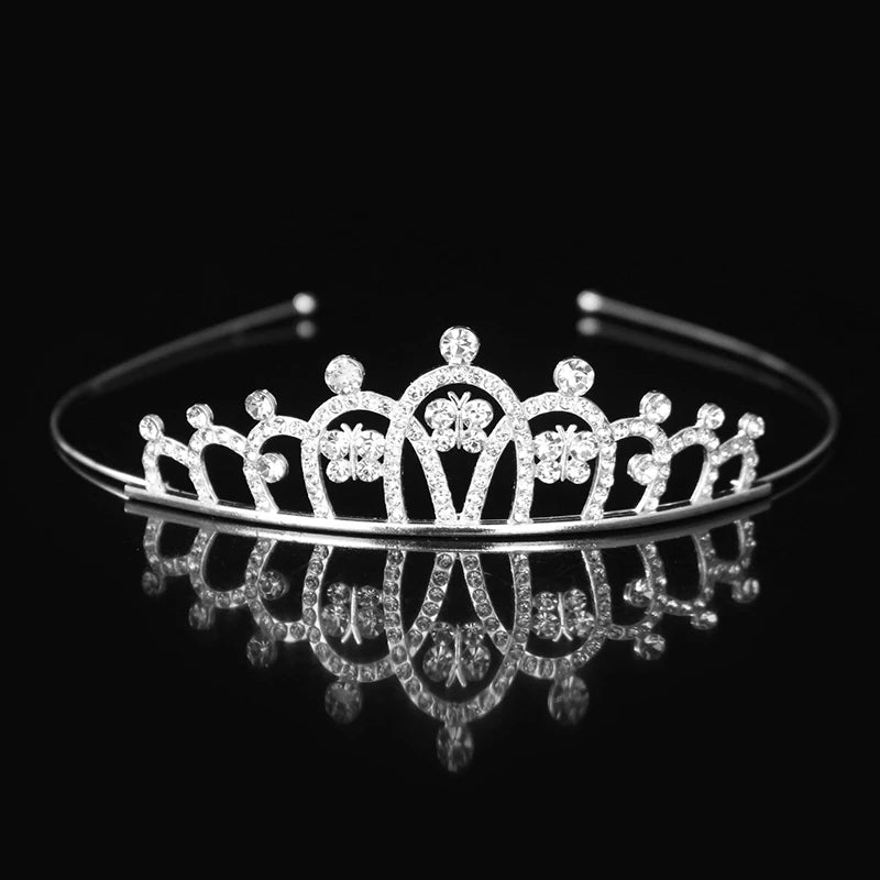 Tiara y corona de princesa de cristal brillante, accesorio para el cabello que refleja en una superficie oscura.