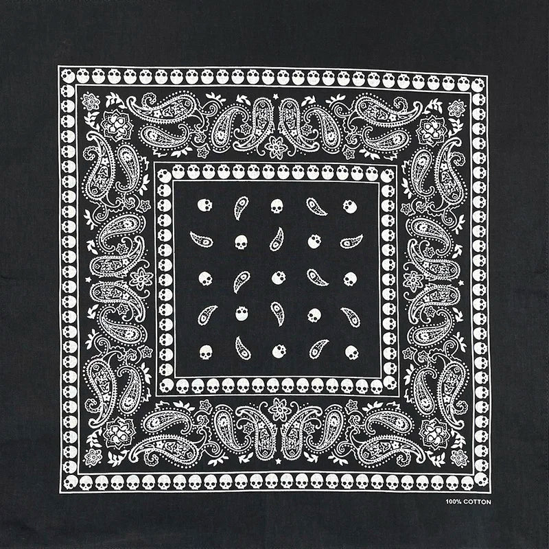 Tela negra con intrincado patrón blanco de calaveras y arabescos decorativos.