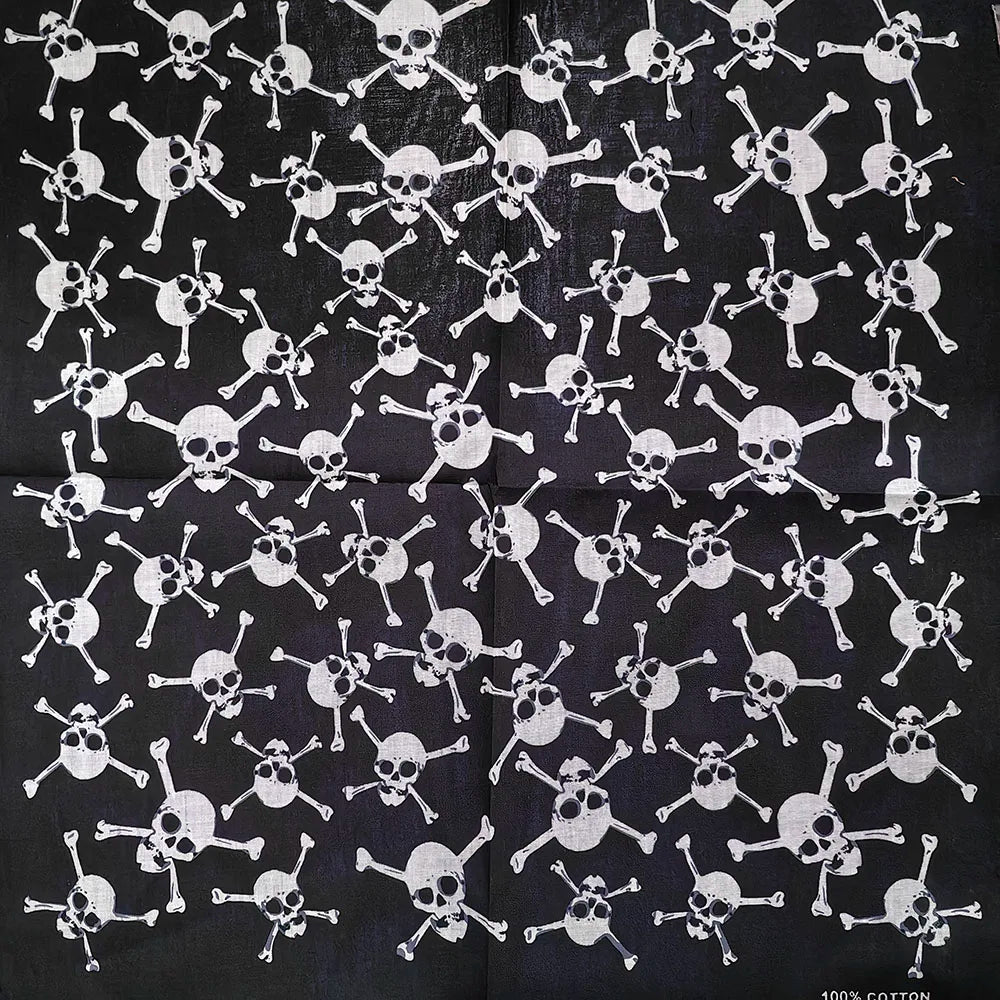 Tela negra con patrón repetitivo de calaveras y tibias cruzadas blancas.