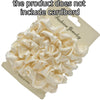 A pile of cream-colored satin hair scrunchies is displayed on a cardboard tag.