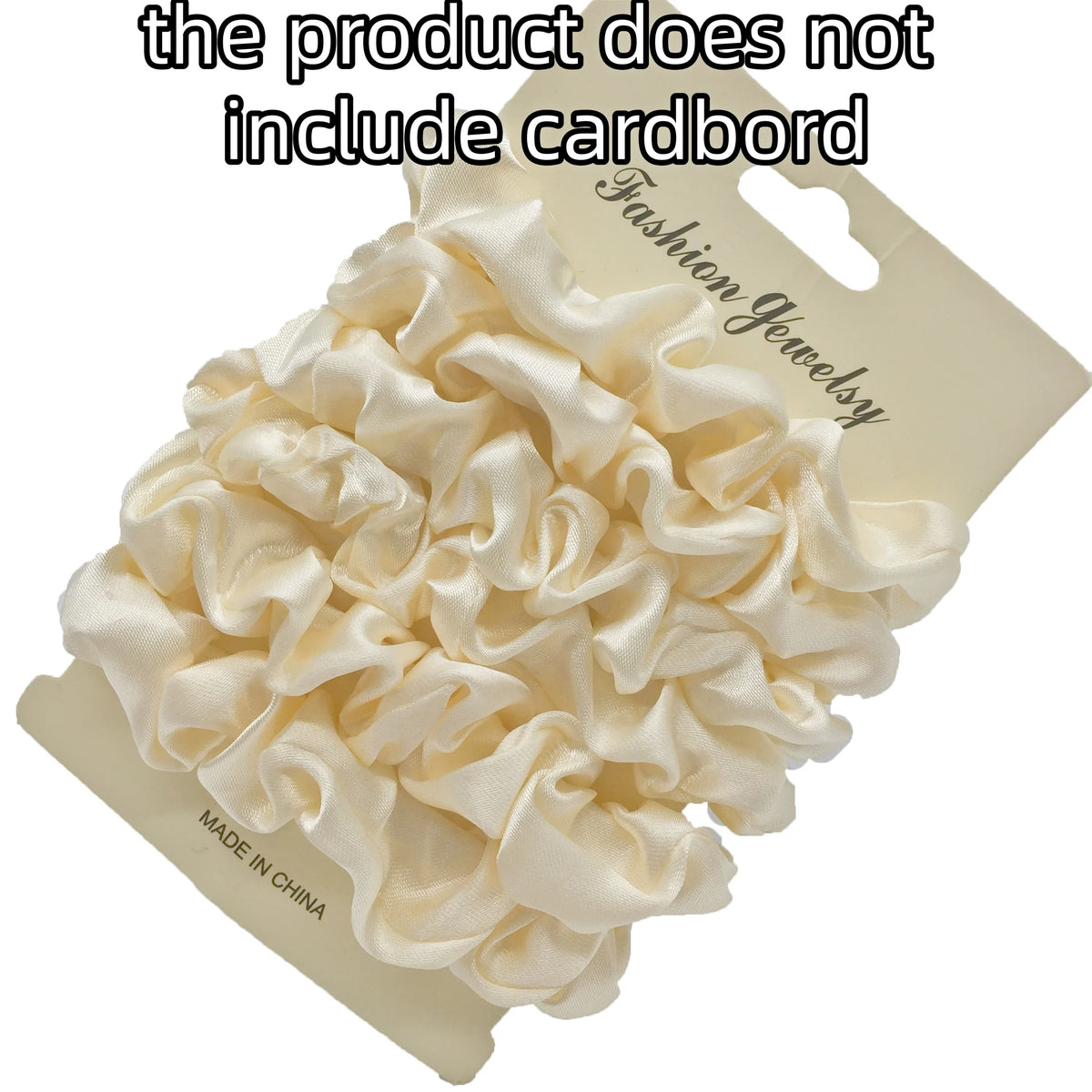 A pile of cream-colored satin hair scrunchies is displayed on a cardboard tag.