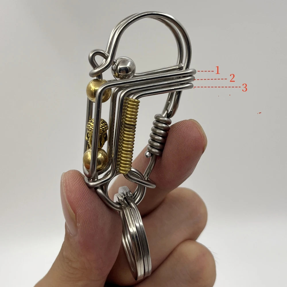 Un porte-clés mécanique en acier inoxydable avec mécanisme à ressort est tenu dans la main d'une personne.