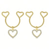 A pair of gold heart dangle non-piercing nipple rings adorned with cubic zirconia stones.