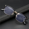Une paire de lunettes vintage à demi-monture avec des verres bleu foncé et des accents dorés posées sur une surface noire.