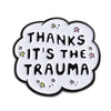 A white enamel lapel pin shaped like a cloud with black text reading Thanks It's the Trauma and small stars.