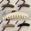 A set of large banana hair clips in various shades of brown and black, shown in different angles.