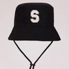 Black sun hat with a white letter S embroidered on the front and an adjustable cord.