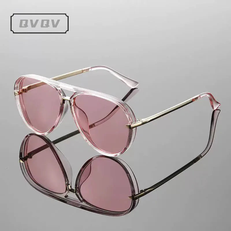 Lunettes de pilot teintées de rose avec des montures en métal vintage, présentées sur fond gris