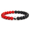 A black and red Yin Yang hand string bracelet with smooth, round beads.