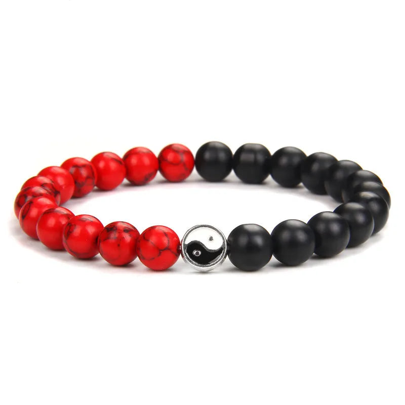 A black and red Yin Yang hand string bracelet with smooth, round beads.