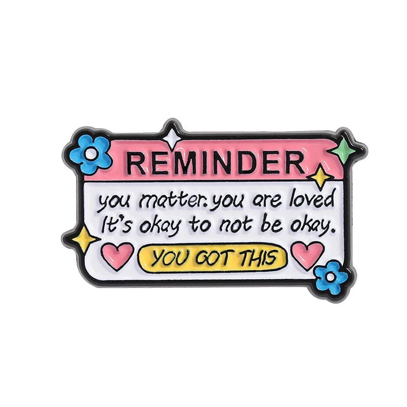 Pink enamel lapel pin with the text REMINDER you matter you are loved it's okay to not be okay to get this