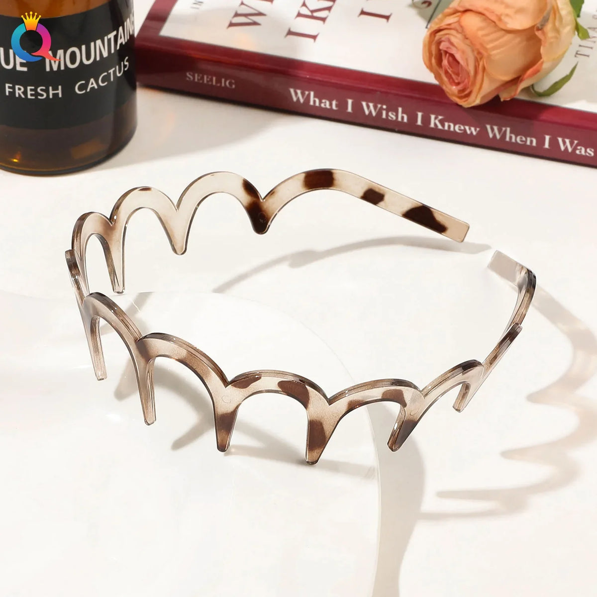 A set of fashion acetate toothed headbands in a marbled brown and cream pattern displayed on a white surface.