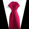 A close-up of a red patterned silk necktie worn under a white dress shirt.